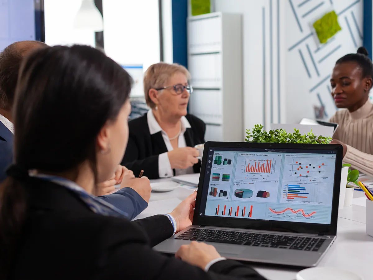Fintech QA team reviewing test results and financial application data on a laptop